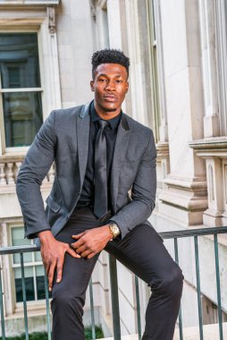 New York 'ta çalışan Afrikalı Amerikalı iş adamı. Şık bir ceket, siyah kravat, kol saati, kolej öğrencisi klasik ofis binasında korkuluklarda oturuyor, mola veriyor, sana bakıyor.