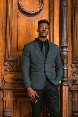 New York 'ta çalışan Afrikalı Amerikalı iş adamı. Modaya uygun bir ceket, siyah atlet, kravat, kol saati, keçi sakallı bir adam klasik tarz kapının önünde duruyor, hoş geldiniz..