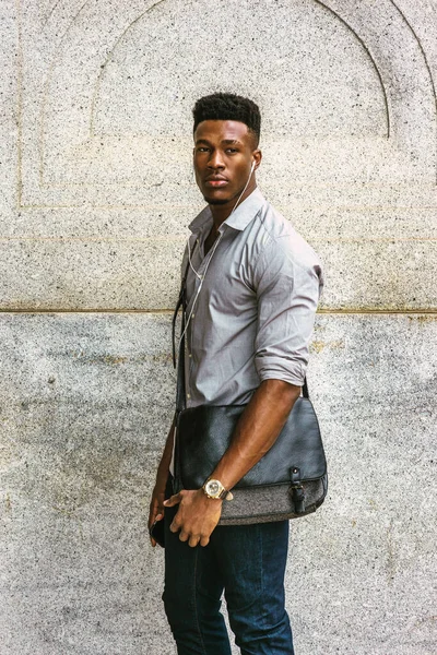 İşe giden bir adam var. Gri gömlekli, kot pantolonlu, kol saati takan, omuz derisi çanta taşıyan, sokakta duvarda dikilmiş kulaklık ve cep telefonuyla müzik dinleyen Afro-Amerikalı bir adam.