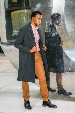 Koyu gri yün palto, pembe atlet, sarı pantolon, siyah deri ayakkabı, papyon, metal ayna duvarında yürüyen,.