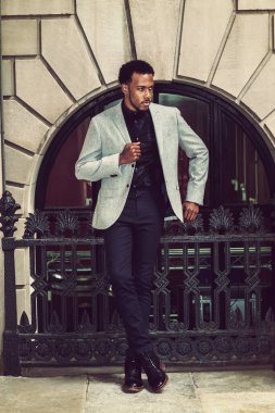 New York 'ta çalışan Afro-Amerikalı iş adamı, gri ceket giyiyor, çiçekli atlet, pantolon, deri ayakkabı giyiyor, korkulukların yanında duruyor, dinleniyor, düşünüyor.. 