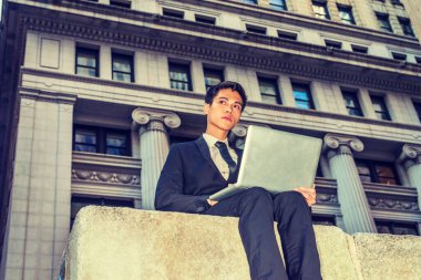 Asyalı Amerikalı üniversite öğrencisi New York 'ta okuyor. Resmi olarak siyah takım elbise, kravat, genç iş adamı sokakta oturuyor, okuyor, dizüstü bilgisayarda çalışıyor..