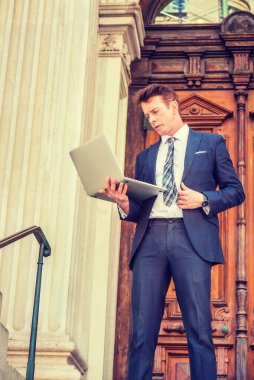 New York 'ta çalışan Amerikalı iş adamı. Siyah takım elbise, desenli kravat, beyaz atlet, klasik ofis kapısında duran bir avukat, aşağı bakıyor, okuyor, dizüstü bilgisayarla çalışıyor..