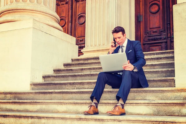 Amerikalı iş adamı seyahat ediyor, New York 'ta çalışıyor, siyah takım elbise giyiyor, deri ayakkabılar giyiyor, ofisin dışındaki merdivenlerde oturuyor, dizüstü bilgisayarda çalışıyor, telefonla arıyor..