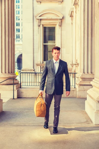 New York 'ta çalışan Amerikalı iş adamı, çizgili ceket, beyaz atlet, pantolon, deri ayakkabı, sarı deri çanta taşıyor, klasik ofis binasında yürüyor, işe gidiyor..