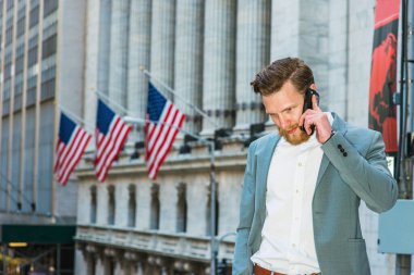 Sakallı, bıyıklı Amerikalı iş adamı, New York 'ta çalışıyor. Öğrenci mavisi takım elbiseli, beyaz gömlekli, bayraklarla sokakta duran, cep telefonuyla konuşan bir adam..