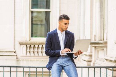 Afrikalı Amerikalı üniversite öğrencisi New York 'ta okuyor. Mavi ceketli, beyaz tişörtlü, kampüsteki klasik ofis binasının parmaklıklarında oturan, dizüstü bilgisayarda okuyan, çalışan..