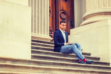 Afrikalı Amerikalı üniversite öğrencisi New York 'ta okuyor. Ceketi, gri pantolonu, kırmızı çorapları, spor ayakkabıları vardı. Adam ofis binasının dışındaki merdivenlerde oturuyor, okuyor, dizüstü bilgisayarda çalışıyor.. 