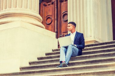 Başarının yolu. Afrikalı Amerikalı üniversite öğrencisi New York 'ta okuyor. Genç adam kampüsteki klasik ofis kapısında oturuyor, okuyor, dizüstü bilgisayarda çalışıyor, başka tarafa bakıyor, düşünüyor.. 