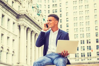 Şehir hayatı. Afrikalı Amerikalı üniversite öğrencisi New York 'ta okuyor. Genç adam caddedeki klasik ofis binasının yanında oturuyor, okuyor, dizüstü bilgisayarda çalışıyor, başını çeviriyor, cep telefonuyla konuşuyor..