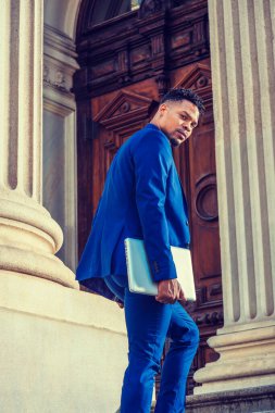 New York 'ta okuyan Afro-Amerikan üniversite öğrencisi, mavi takım elbiseli, dizüstü bilgisayar taşıyan, merdivenlerden klasik ofis binasına çıkan, geri dönüp sana bakan..