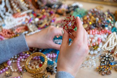 Bir yığın mücevheri tutan kadın elleri, yakın plan.