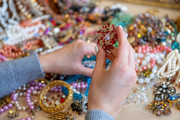 Bir yığın mücevheri tutan kadın elleri, yakın plan.