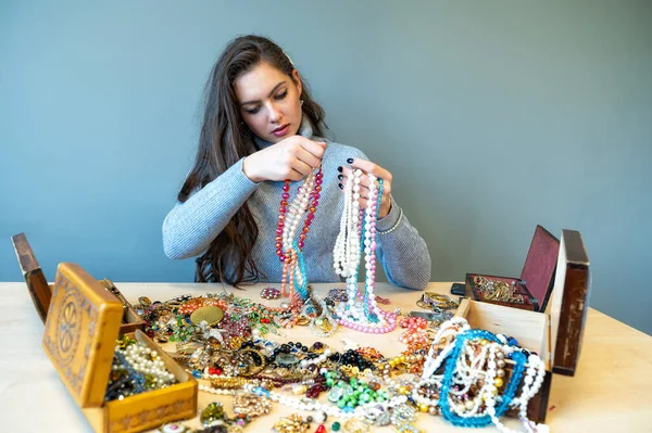 Schlanke Brünette Sitzt Tisch Mit Viel Schmuck Und Wählt Und — Stockfoto