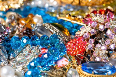 Çeşitli renkli parlak mücevherler ve kostüm mücevherlerinin soyut arkaplanı, yumuşak, seçici odaklanma