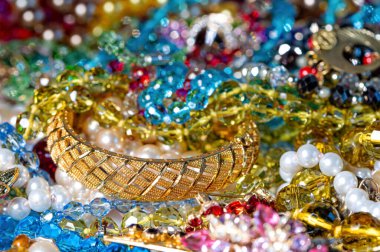 Çeşitli renkli parlak mücevherler ve kostüm mücevherlerinin soyut arkaplanı, yumuşak, seçici odaklanma