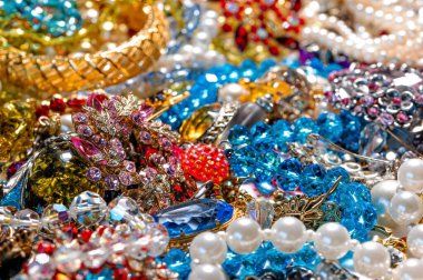 Çeşitli renkli parlak mücevherler ve kostüm mücevherlerinin soyut arkaplanı, yumuşak, seçici odaklanma