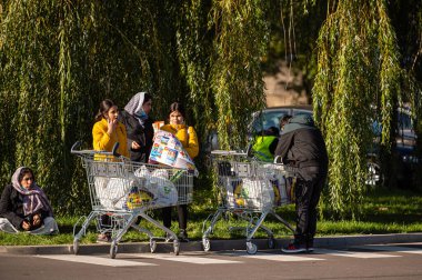 Riga, Letonya, 9 Ekim 2021: LIDL süpermarket otoparkında alışveriş arabalarıyla dolu bir grup insan