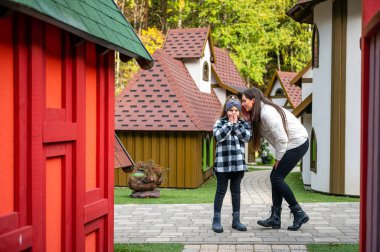 İki kız kardeş renkli cüce kasaba evleri arasında yürür, konuşur ve sırlarını paylaşırlar.