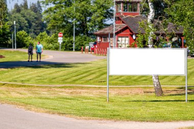 Yürüyüş yolunun yanındaki parkta boş reklam panosu, açık hava reklam konsepti, maket.