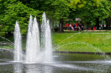 Güneşli bir bahar gününde şehir parkındaki çeşme Riga, Letonya, fotokopi alanı