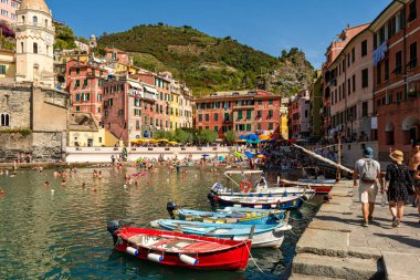 Vernazza, İtalya - 10 Ağustos 2021: Santa Margherita di Antiochia Kilisesi ile şehir manzarası ve ön planda tekneler