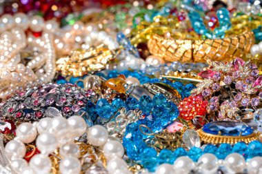 Çeşitli renkli parlak mücevherler ve kostüm mücevherlerinin soyut arkaplanı, yumuşak, seçici odaklanma