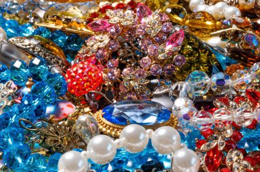 Çeşitli renkli parlak mücevherler ve kostüm mücevherlerinin soyut arkaplanı, yumuşak, seçici odaklanma