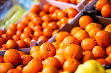 Marketteki ahşap kutularda olgun mandalinalar, portakallar ve diğer meyveler, yakın çekim