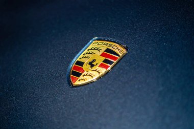 Riga, Letonya, 24 Eylül 2021: Mavi arabanın kaputunda Porsche şirketinin logosu görülüyor.