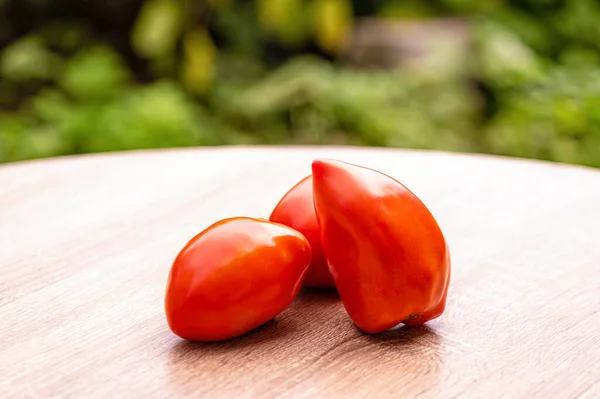 Tomates Rojos Frescos Una Mesa Madera Contra Fondo Borroso Hojas —  Fotos de Stock