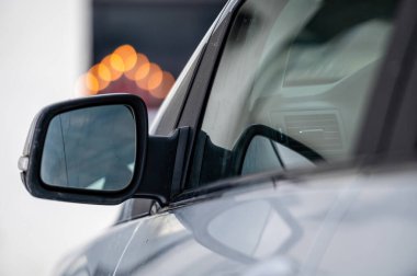 Gri, parlak bir arabanın dikiz aynası, yakın plan.