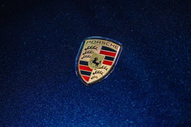 Riga, Letonya, 24 Eylül 2021: Mavi arabanın kaputunda Porsche şirketinin logosu görülüyor.