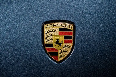 Riga, Letonya, 24 Eylül 2021: Mavi arabanın kaputunda Porsche şirketinin logosu görülüyor.