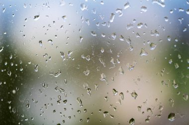 Pencere camındaki yağmur damlaları, seçici odak, yağmurlu şehir arkaplanı, yağmur damlalarının dokusu, ıslak cam.