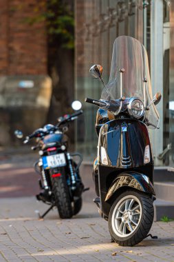 Riga, Letonya - 7 Ekim 2020 Vespa scooter ve motosiklet eski kasabanın kaldırımına park edildi.