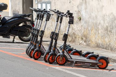 Pisa, İtalya - 9 Ağustos 2021: Caddenin kenarında kiralık bir dizi HELBIZ elektrikli scooter
