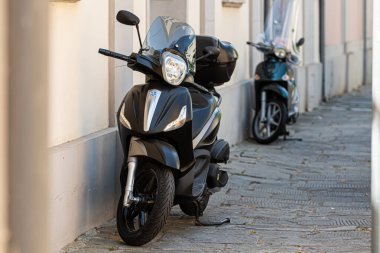 Pisa, İtalya - 9 Ağustos 2021: Eski şehir sokağının dar tarafında bir sıra motosiklet