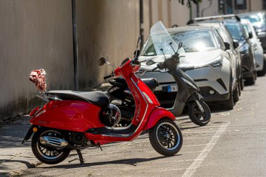 Pisa, İtalya - 9 Ağustos 2021: Eski şehrin dar tarafında bir sıra motosiklet ve araba