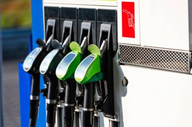 Benzin istasyonunda yeşil ve siyah yakıt ikmal silahlarıyla sıra halinde, yakın çekim, yatay çekim