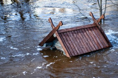 Bahar sellerinde taşan bir kuş evinin çatısına. Letonya, Dobele 'deki Berze Nehri' nde bir besleyici.