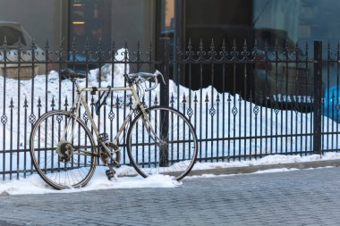 Riga, Letonya - 17 Şubat 2021: Spor bisikleti park edilmiş ve kış kentinde kaldırıma kilitlenmiştir.