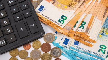 Avro para birimi sikkelerinin, banknotların ve hesap makinelerinin yakın planı, finans planlama kavramı