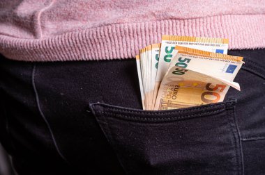 Kotun arka cebindeki Euro banknotları. Zengin insanlar kavramı, para biriktirmek ya da harcamak, yakın plan