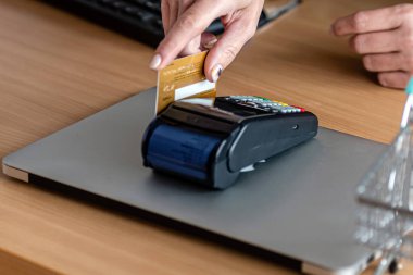 Kadın kredi kartı, kredi kartı okuyucusu ve finans konseptiyle online alışveriş yapmak için ödeme kartı terminalini kullanıyor.