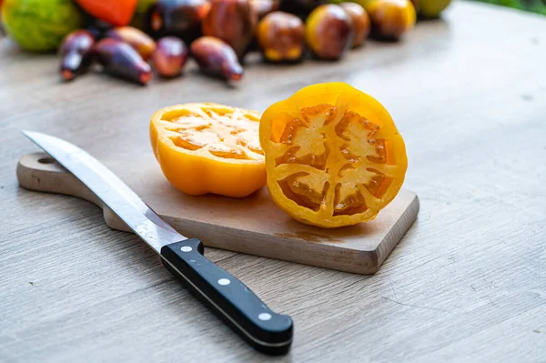 Tisch Mit Schneidebrett Mit Geschnittenen Tomaten Und Verschieden Farbigen Tomaten — Stockfoto