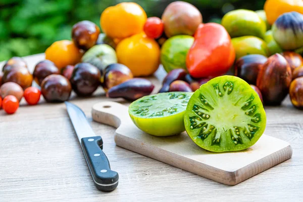Mesa Con Una Tabla Cortar Con Tomates Rodajas Tomates Diferentes —  Fotos de Stock
