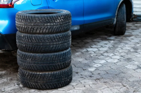 一套冬季轮胎旁边的汽车在车轮服务 概念季节性的轮胎更换 — 图库照片