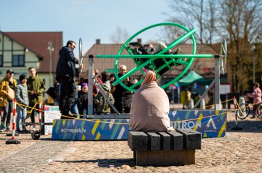 Dobele, Letonya - 17 Nisan 2022: şehir meydanında taşınabilir çekimler, Aerotrim-insan jiroskobu, ayrıca 3D salıncak olarak da bilinir.