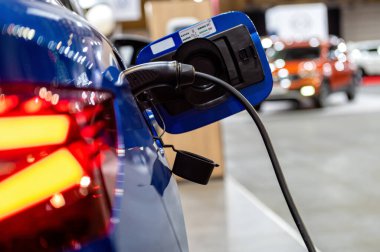 plug of the charging cable plugged into an electric car, charging an electric car at the station
